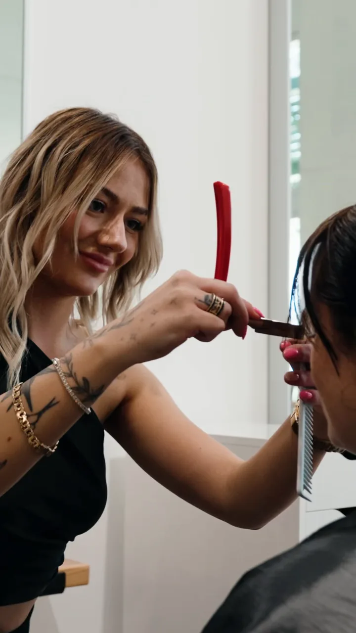 Georgia detailing a client’s face-frame with a straight razor at Scotch Bonnet.