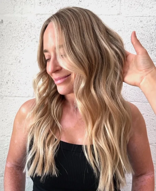 Bright blonde balayage with a face-framing money piece and a soft rooted melt.