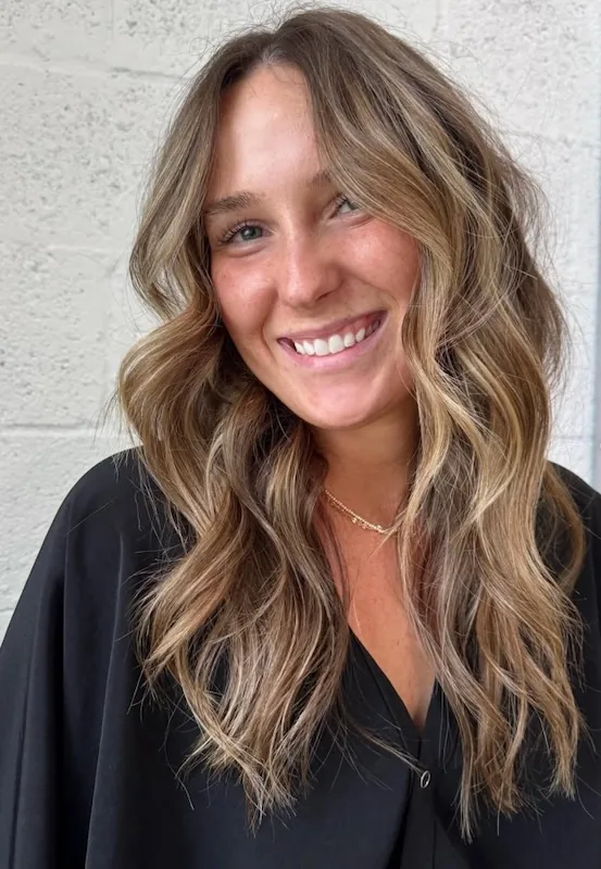 Lived-in bronde balayage with a brightened face frame and beachy waves.