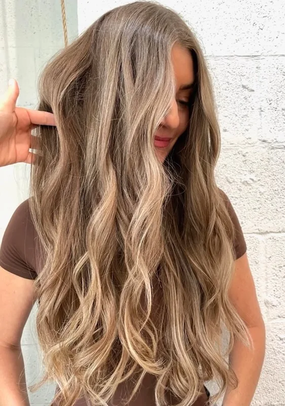 Long soft bronde balayage brushed into relaxed waves.