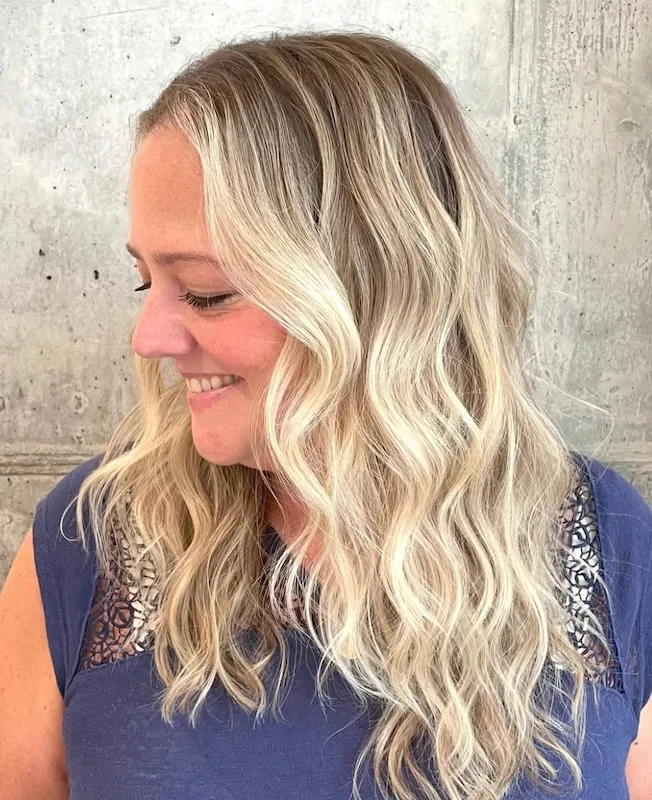 Creamy blonde balayage in relaxed beach waves.