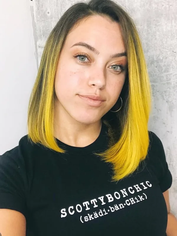 Dark roots melting into a vivid yellow ombre lob, pressed glass-straight.