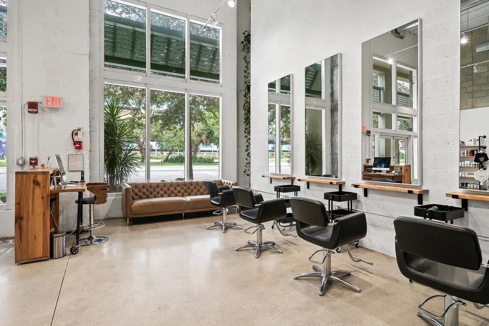 Glass entry doors, a wall of windows onto downtown West Palm Beach and a leather sofa in the waiting area.